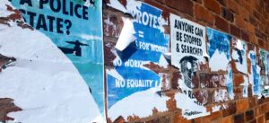 Distressed posters on a brick wall background protesting civil and human rights breaches