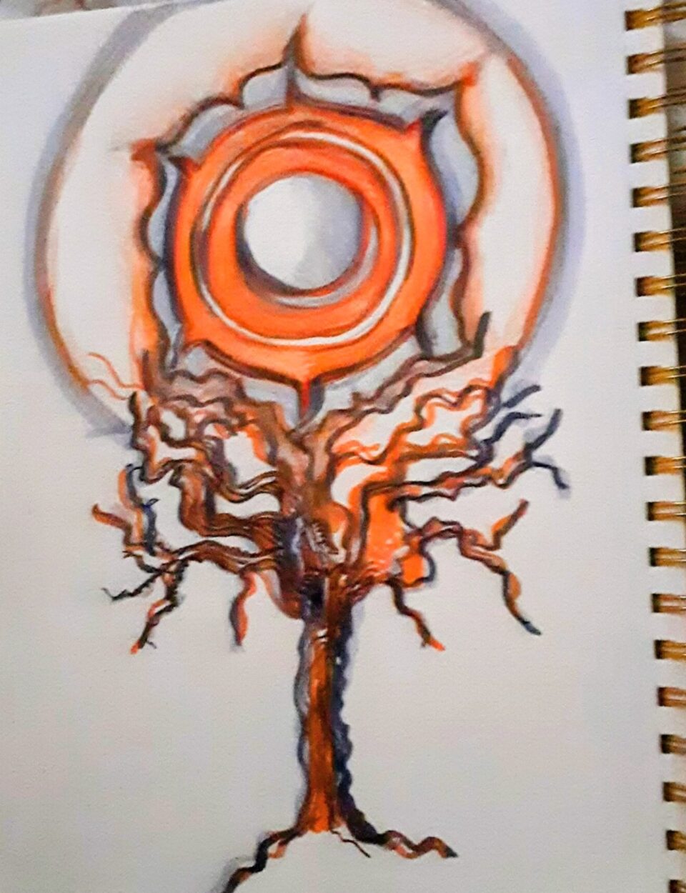 An orange sacral chakra above an orange and grey tree drawn together in an illustration in a ring bound notebook